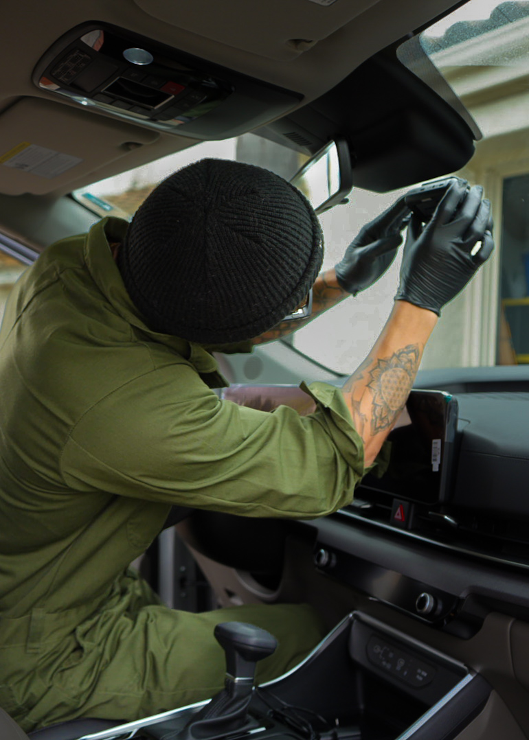 Technician polishing paintwork to remove swirls and haze on a luxury car