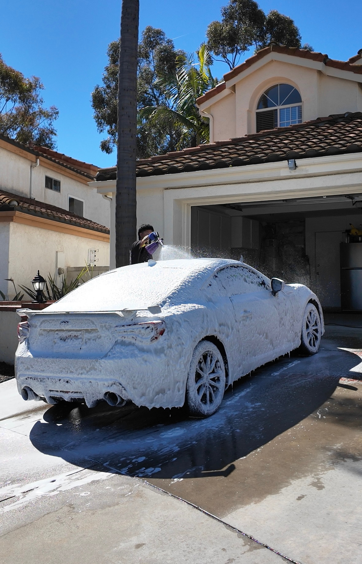 Vehicle covered in snow foam during a wash and wax service