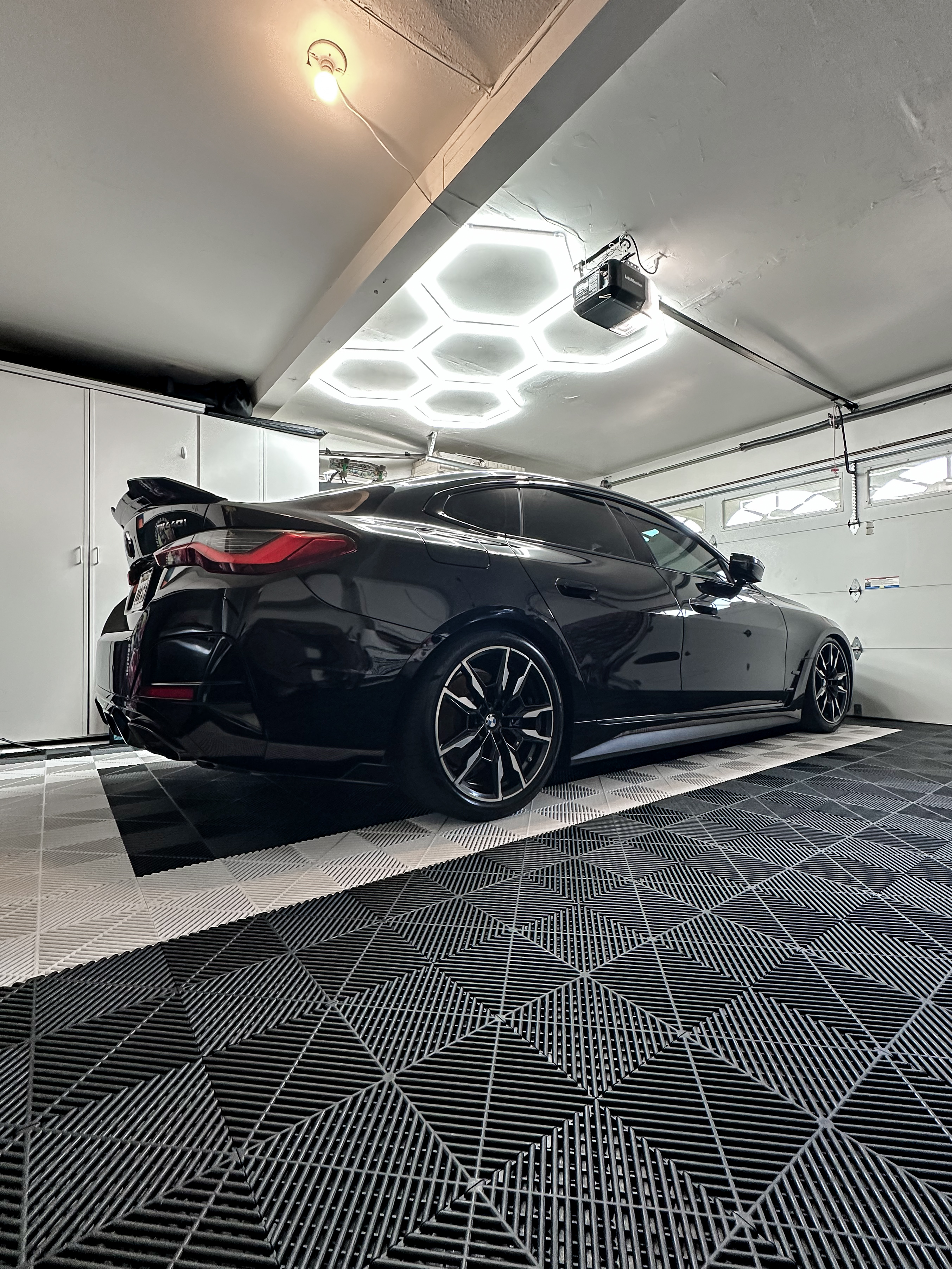 Black BMW with a glossy finish inside the XP Garage workspace